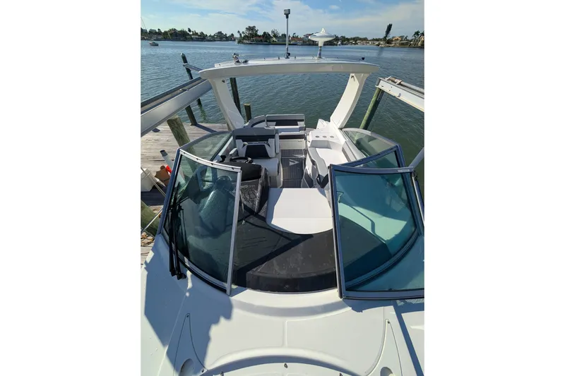 Slide: The Image of 2022 Monterey 295SS Super Sport boat docked by the water. - 24