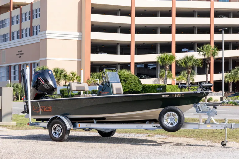 The Image of 2025 Mako 18 Pro Skiff Backwater Edition on trailer, parked near a multi-story building. - 1