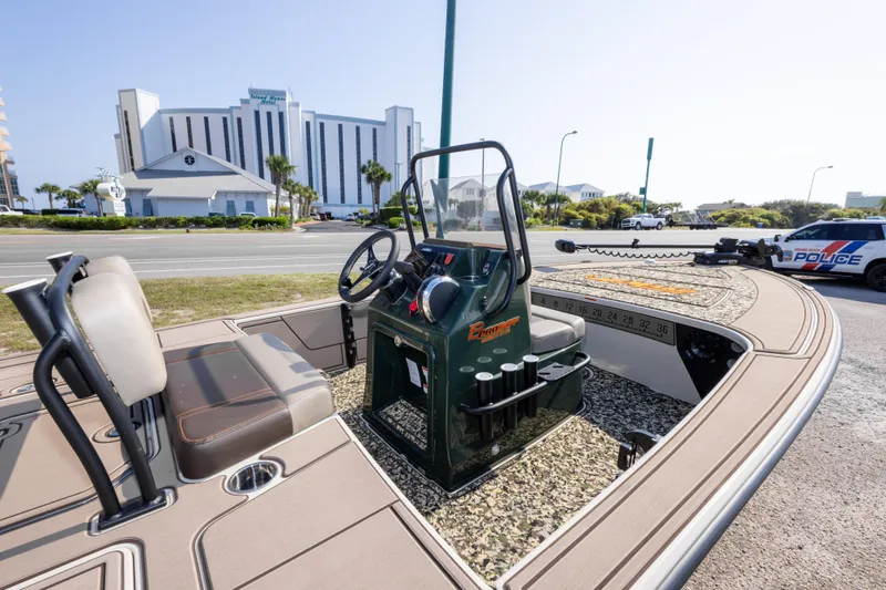 Slide: The Image of 2025 Mako 18 Pro Skiff Backwater Edition boat parked near a road with buildings. - 13