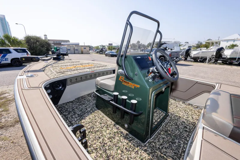 Slide: The Image of 2025 Mako 18 Pro Skiff Backwater Edition boat with camo interior and steering console. - 15