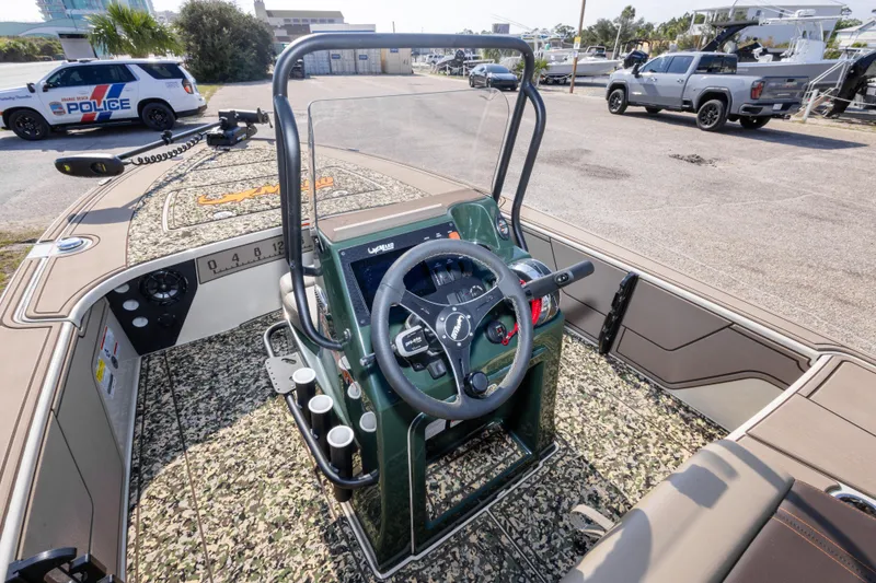 Slide: The Image of 2025 Mako 18 Pro Skiff Backwater Edition boat interior with steering console and camo flooring. - 21