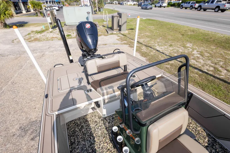 Slide: The Image of 2025 Mako 18 Pro Skiff Backwater Edition boat with outboard motor, parked on roadside. - 23