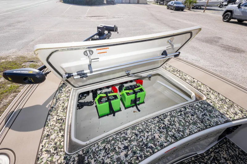 Slide: The Image of 2025 Mako 18 Pro Skiff Backwater Edition with open storage compartment and batteries. - 26