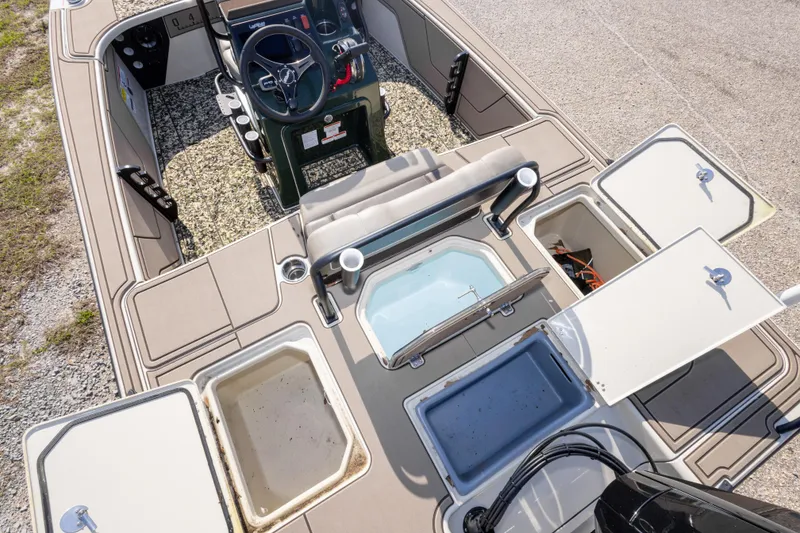Slide: The Image of 2025 Mako 18 Pro Skiff Backwater Edition interior with open storage compartments and steering console. - 27
