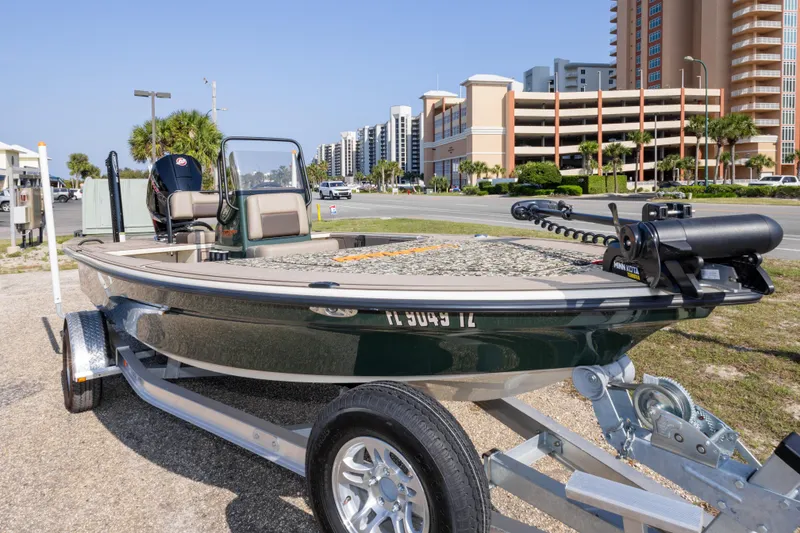 Slide: The Image of 2025 Mako 18 Pro Skiff Backwater Edition boat on trailer, urban background. - 3
