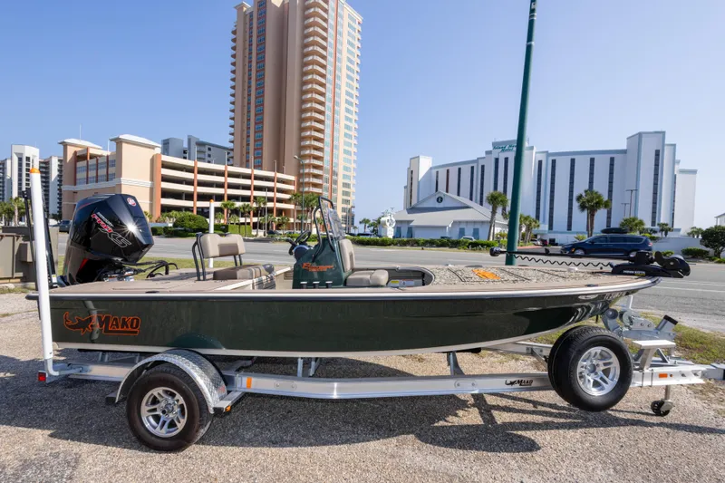 Slide: The Image of 2025 Mako 18 Pro Skiff Backwater Edition boat on trailer, urban backdrop. - 4