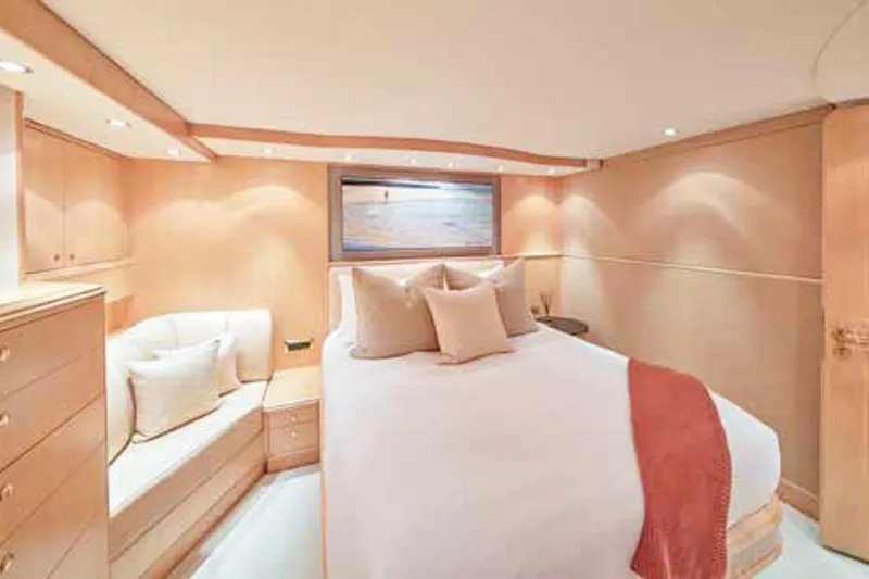 Slide: The Image of Luxurious Crescent Custom Yachts bedroom interior, 2000 model, featuring elegant wood cabinetry and cozy bedding. - 11