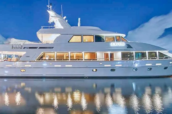 Slide: The Image of Luxurious Crescent Custom Yacht deck with elegant seating, tables, and umbrellas, overlooking a marina at night. - 22