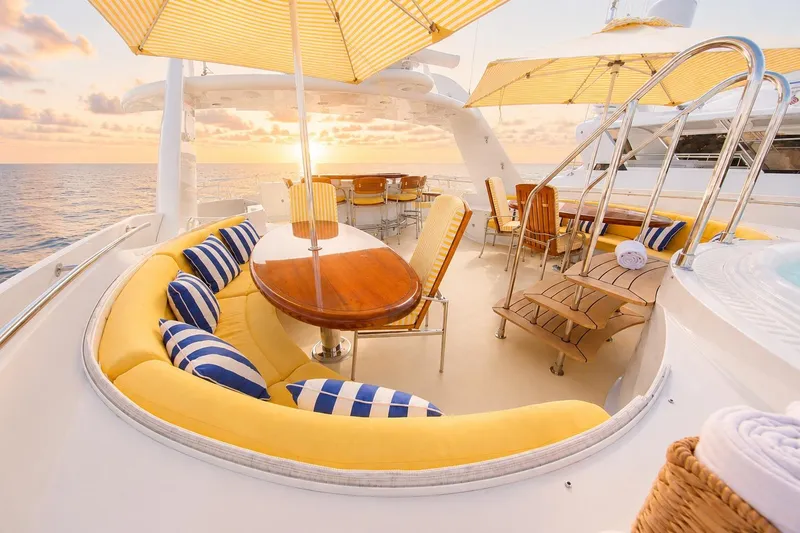 Slide: The Image of Luxurious Crescent Custom Yacht deck with elegant seating, striped cushions, and sunset ocean view, 2000 model. - 48