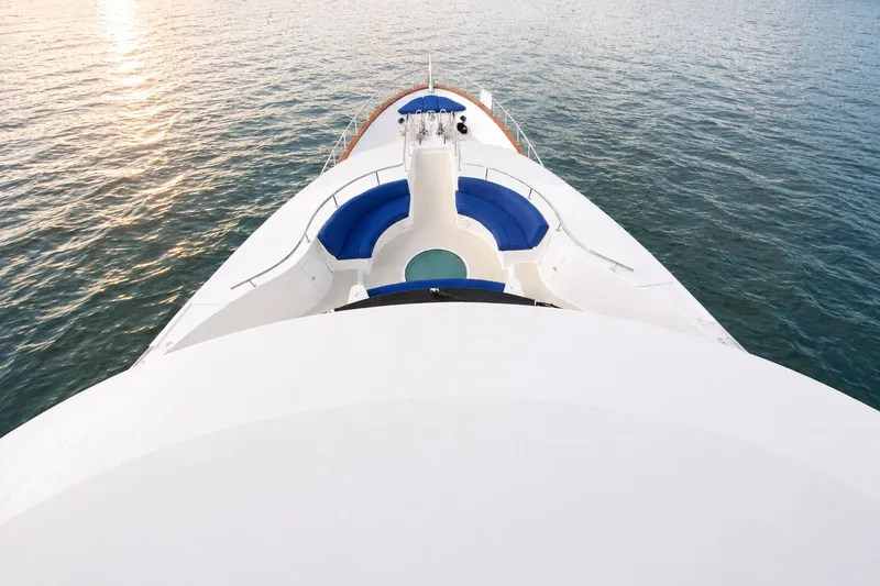Slide: The Image of Luxurious Crescent Custom Yacht from 2000 with elegant blue seating on calm waters. - 54