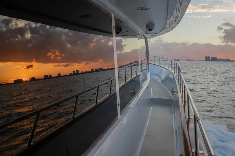 Slide: The Image of Luxurious Crescent Custom Yacht cruising at sunset, 2000 model, with city skyline in the background. - 55