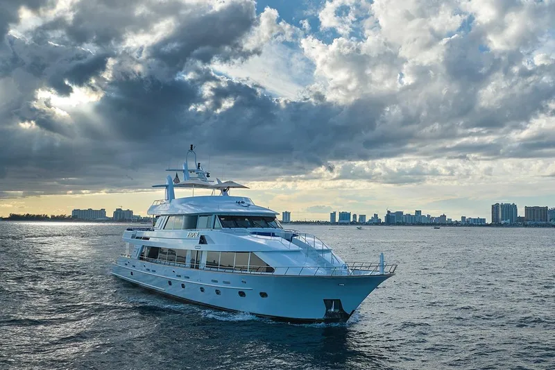 Slide: The Image of Luxurious 2000 Crescent Custom Yacht cruising under dramatic cloudy skies near city skyline. - 59
