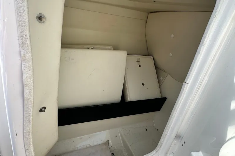Slide: The Image of Storage compartment of a 2016 Yamaha 242 Limited S boat, featuring white interior panels. - 24