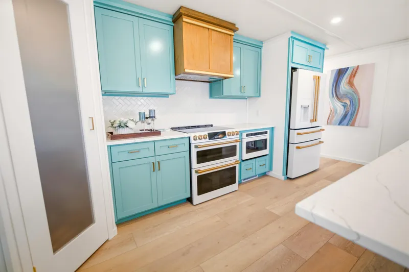 Slide: The Image of Modern kitchen in 2026 Sumerset Luxe III Show Boat with turquoise cabinets and white appliances. - 2