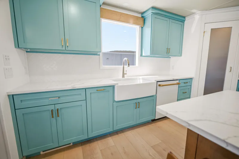 Slide: The Image of Modern kitchen with turquoise cabinets, farmhouse sink, and marble countertops in Sumerset Luxe III Show Boat 2026. - 4