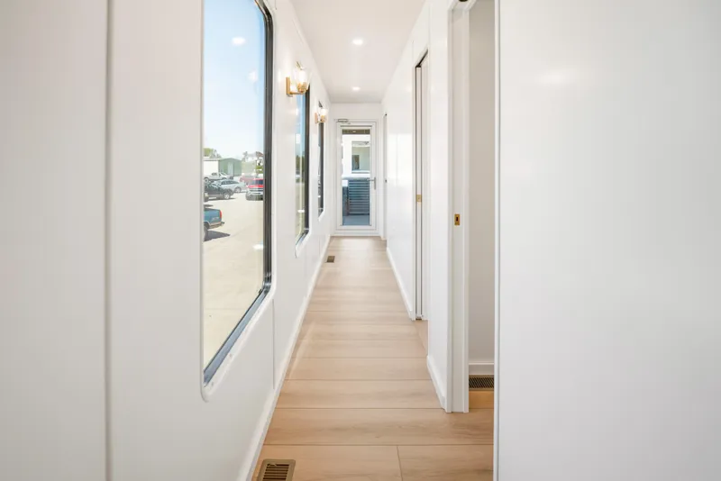 Slide: The Image of Bright hallway interior of 2026 Sumerset Luxe III Show Boat with large windows and wooden flooring. - 9