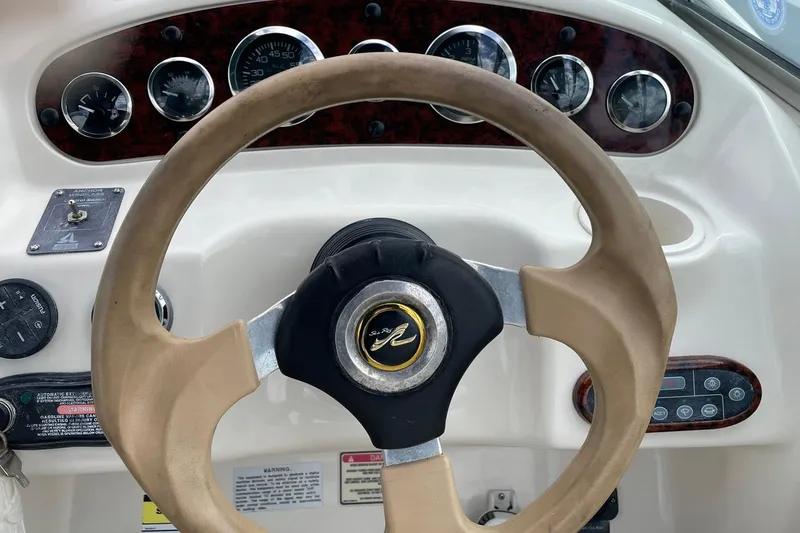 Slide: The Image of Steering wheel and dashboard of a 2002 Sea Ray 225 Weekender boat. - 6