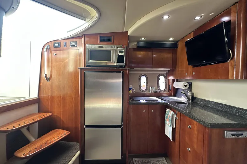 Slide: The Image of 2007 Cruisers Yachts 390 Express Coupe interior with kitchen, microwave, fridge, and TV. - 20