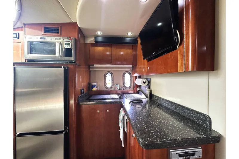 Slide: The Image of 2007 Cruisers Yachts 390 Express Coupe kitchen with modern appliances and sleek wood cabinetry. - 21