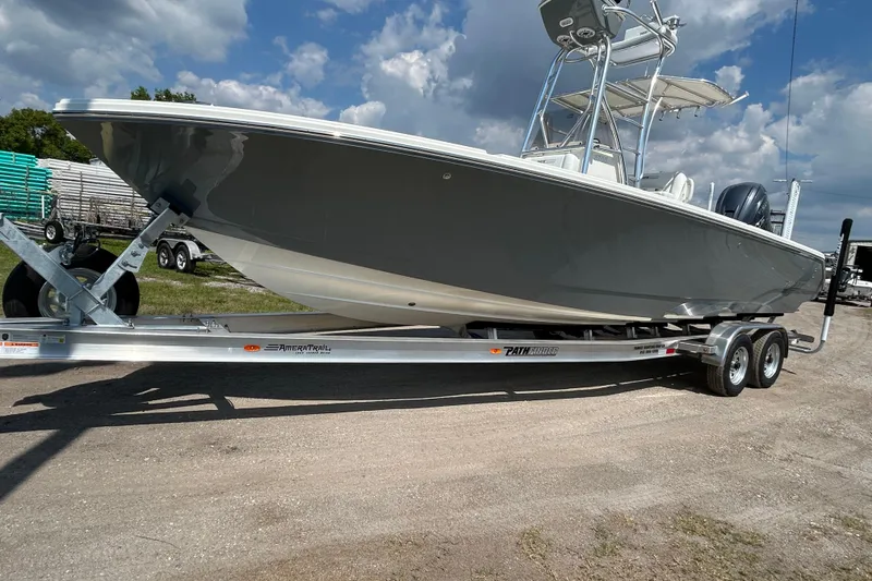Slide: The Image of 2026 Pathfinder 2700 Open boat on trailer under a partly cloudy sky. - 2