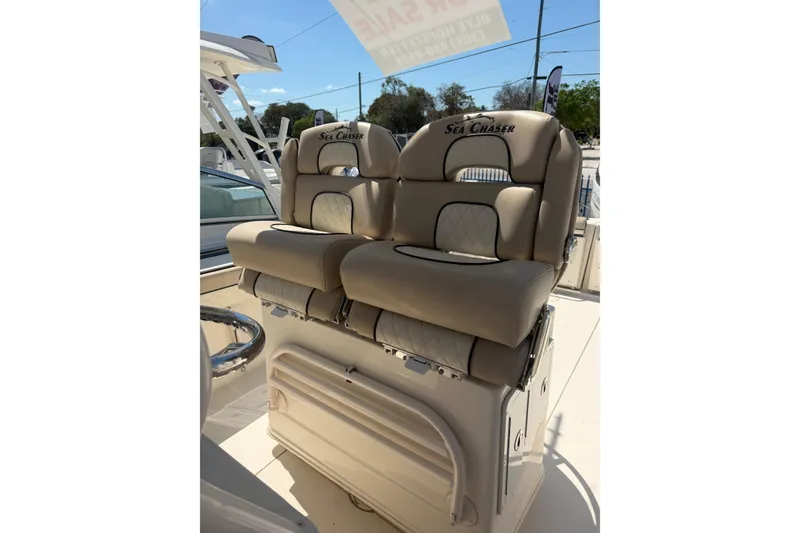 Slide: The Image of 2021 Sea Chaser 30 HFC CC boat seats, beige leather, outdoor setting. - 13