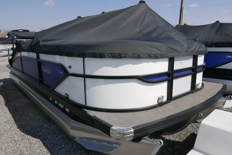 Slide: The Image of 2023 Barletta Cabrio 22UC pontoon boat with cover, parked on gravel. - 15