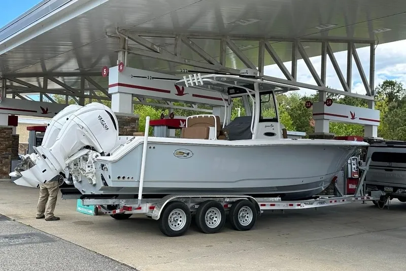 The Image of 2022 Sea Hunt Gamefish 30 boat on trailer at gas station. - 0
