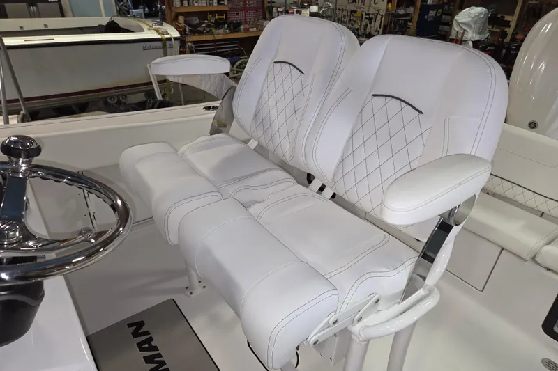Slide: The Image of 2026 Sportsman Heritage 231 Center Console boat with white cushioned seating and steering wheel. - 11