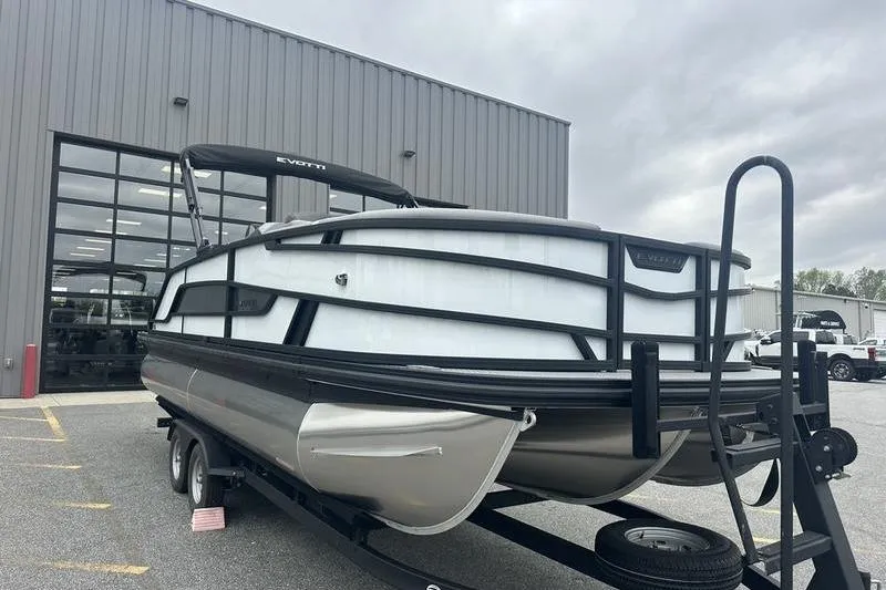 Slide: The Image of 2026 Evotti 521QL pontoon boat on trailer outside industrial building. - 6