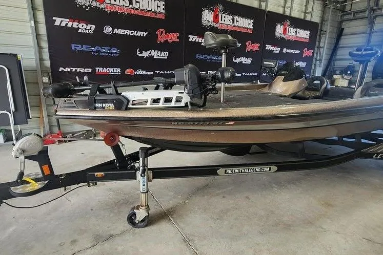 Slide: The Image of 2014 Legend 199 Alpha DC boat on trailer in showroom with promotional banners. - 3