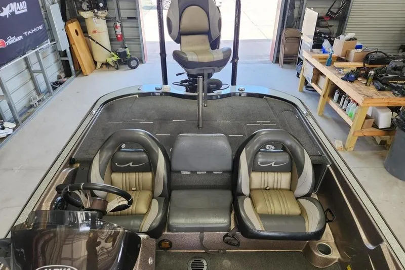 Slide: The Image of 2014 Legend 199 Alpha DC boat interior with seating and steering wheel in a garage. - 7