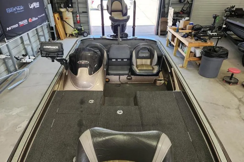 Slide: The Image of 2014 Legend 199 Alpha DC boat interior with Lowrance equipment in a garage setting. - 8