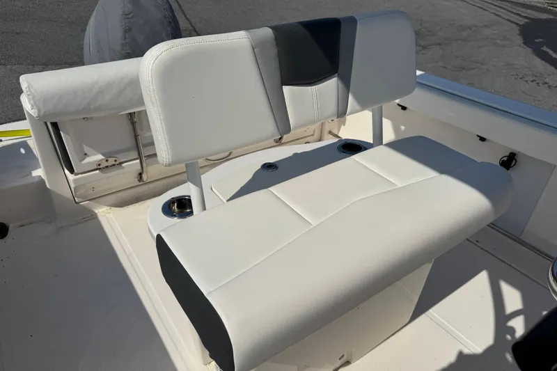 Slide: The Image of 2023 Robalo R222 Center Console boat seat with white upholstery and cup holders. - 2