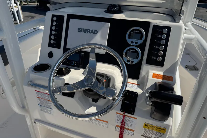 Slide: The Image of 2023 Robalo R222 Center Console boat dashboard with steering wheel and controls. - 5