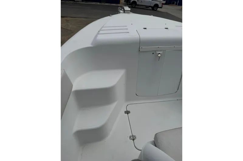 Slide: The Image of 1998 Donzi 30 ZF Daytona boat interior with white seating and storage compartment. - 9