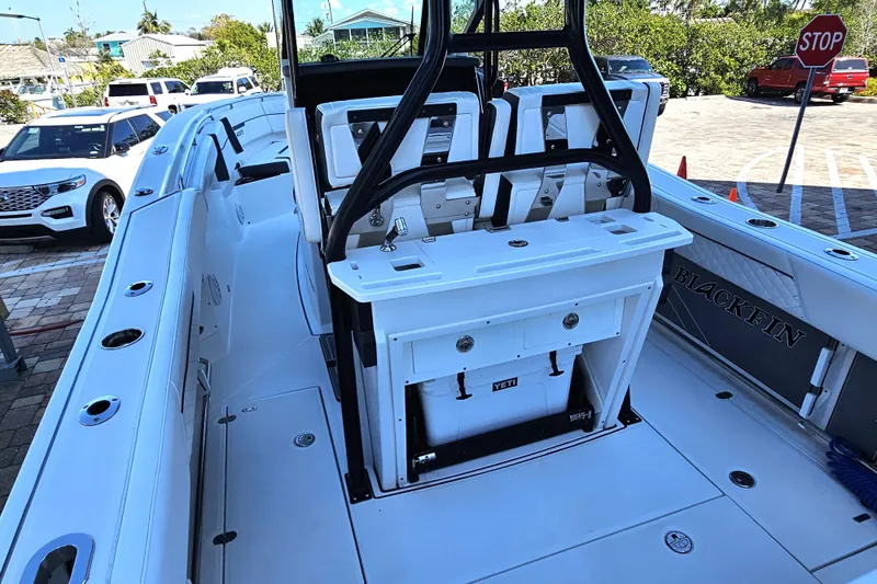 Slide: The Image of 2022 Blackfin 272 CC boat interior with seating and storage, parked outdoors. - 12