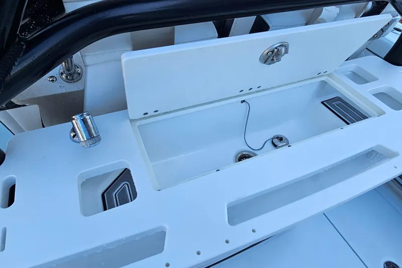 Slide: The Image of 2022 Blackfin 272 CC boat storage compartment with open lid and drain plug. - 15