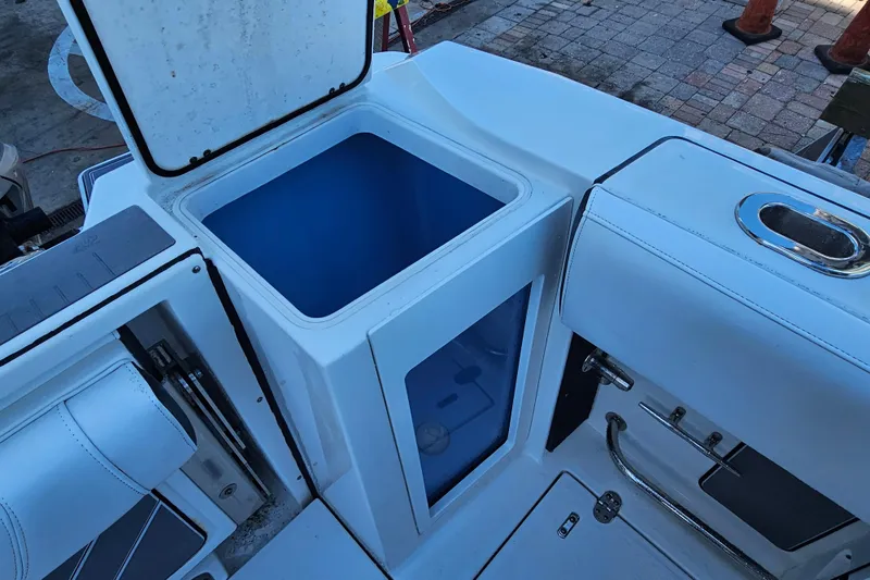 Slide: The Image of 2022 Blackfin 272 CC boat interior with open storage compartment and seating. - 16