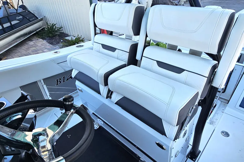Slide: The Image of 2022 Blackfin 272 CC boat interior with white cushioned seats and steering wheel. - 20