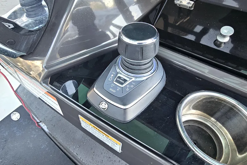 Slide: The Image of Joystick control on 2022 Blackfin 272 CC boat dashboard, next to a cup holder. - 22