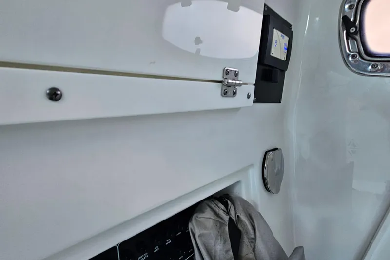 Slide: The Image of Interior view of a 2022 Blackfin 272 CC boat, featuring storage and control panel. - 33