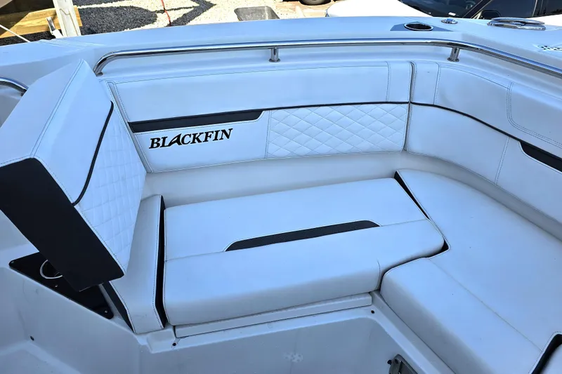 Slide: The Image of 2022 Blackfin 272 CC boat interior with white cushioned seating and logo. - 37