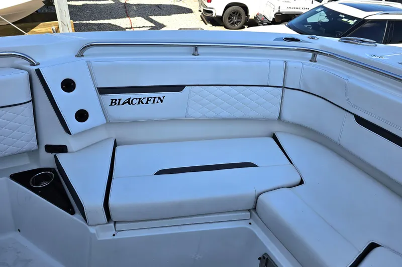 Slide: The Image of 2022 Blackfin 272 CC boat interior with white cushioned seating and logo. - 45