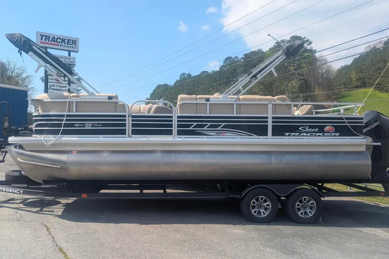 The Image of 2022 Sun Tracker SportFish 22 XP3 pontoon boat on trailer, parked outdoors. - 0