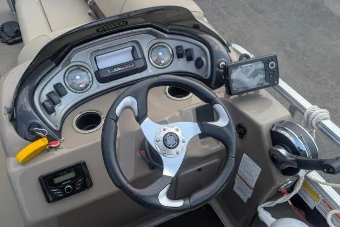 Slide: The Image of 2022 Sun Tracker SportFish 22 XP3 dashboard with steering wheel and navigation controls. - 2