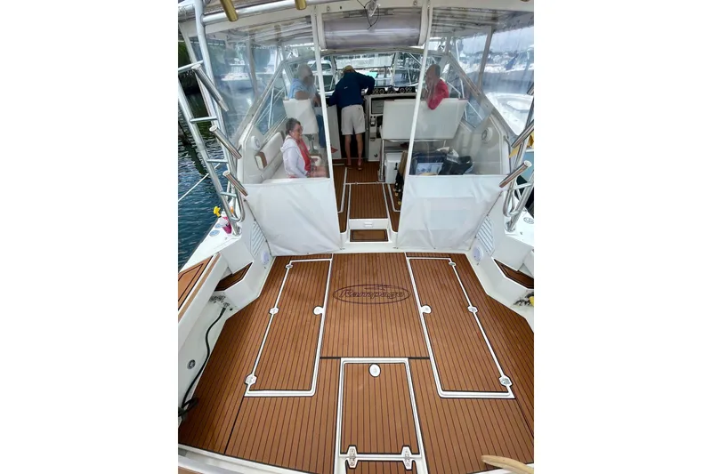Slide: The Image of 1990 Rampage 36 Express boat interior with teak flooring and passengers onboard. - 12