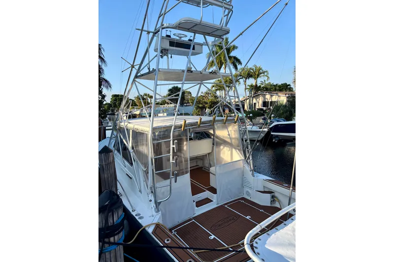 Slide: The Image of 1990 Rampage 36 Express boat with tower, docked near palm trees. - 7