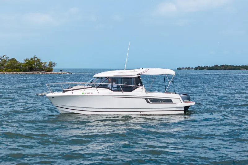 The Image of 2020 Jeanneau NC 795 boat cruising on a calm sea near a small island. - 0