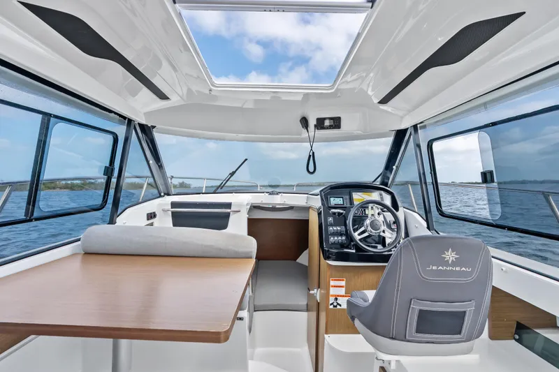 Slide: The Image of Interior of 2020 Jeanneau NC 795 boat with steering wheel and seating area. - 10