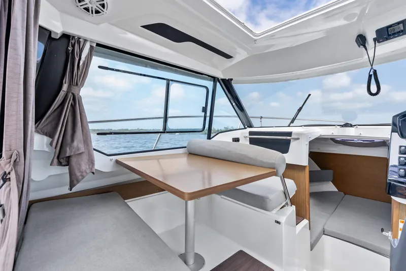 Slide: The Image of Interior of 2020 Jeanneau NC 795 boat with seating and table, overlooking water. - 11